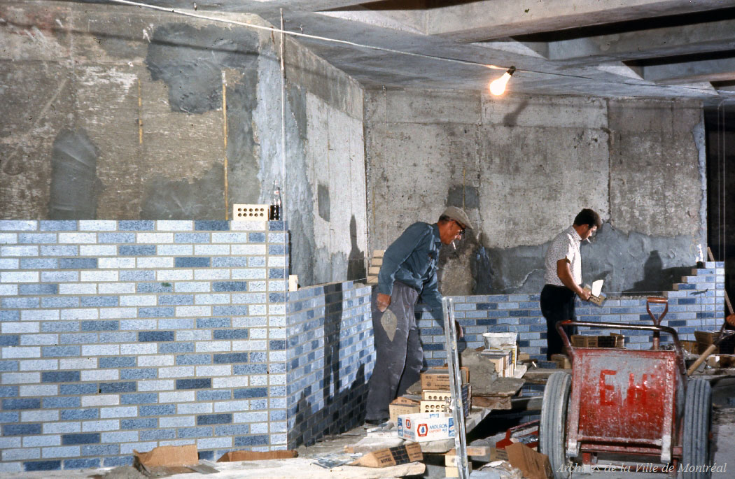 Workers install the brickwork along the zigzag platform walls during the station's construction