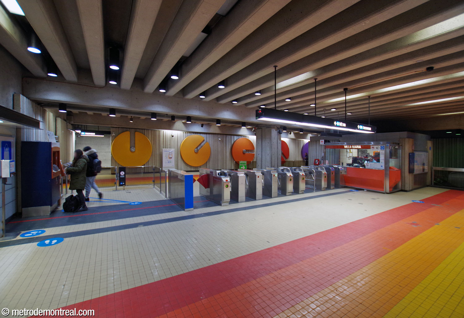 Les tourniquets de la billetterie. L'une des suites de sculptures murales, œuvre de l'architecte de la station André Léonard, orne le mur au fond de la salle de contrôle.